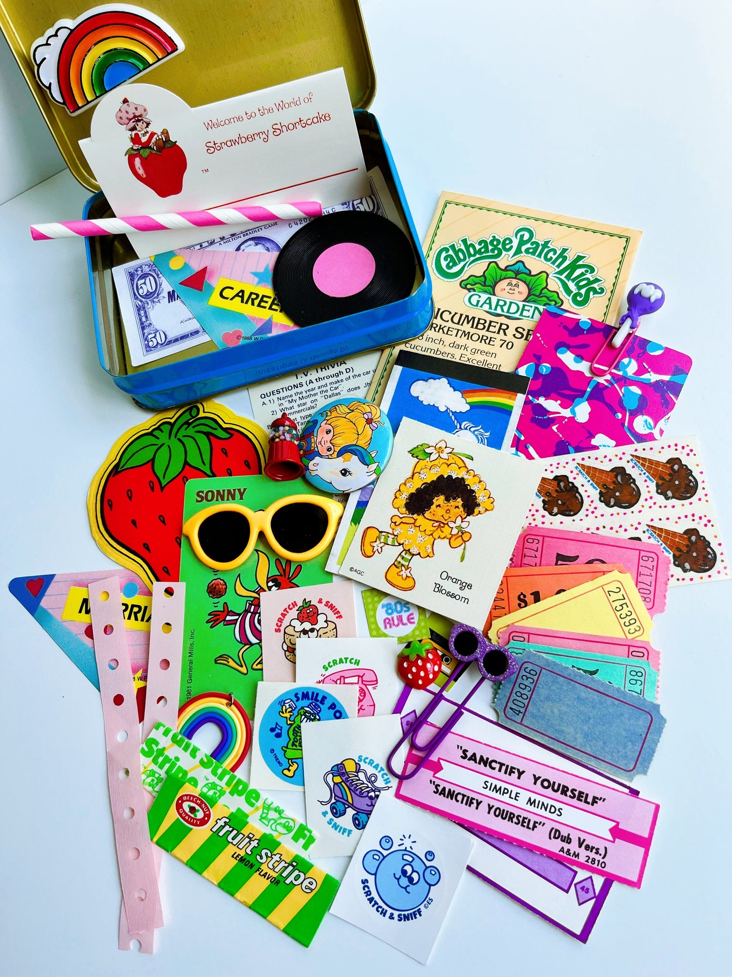 Vintage rainbow tin filled with 80’s themed ephemera & pieces